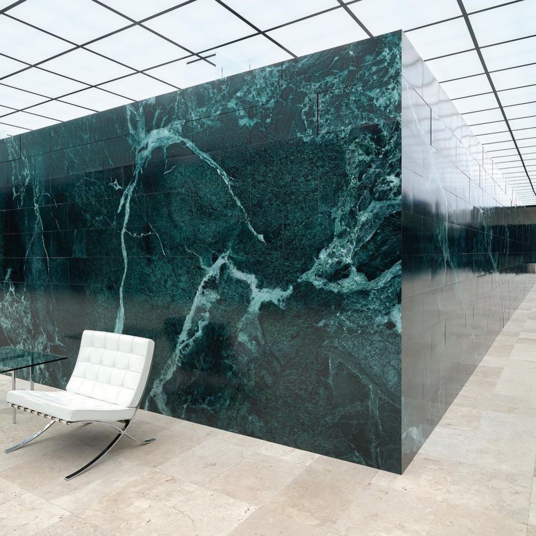 Laufsteg-Bühnenbild mit grünem Marmor und weißen Barcelona-Sesseln der Louis-Vuitton-Show.