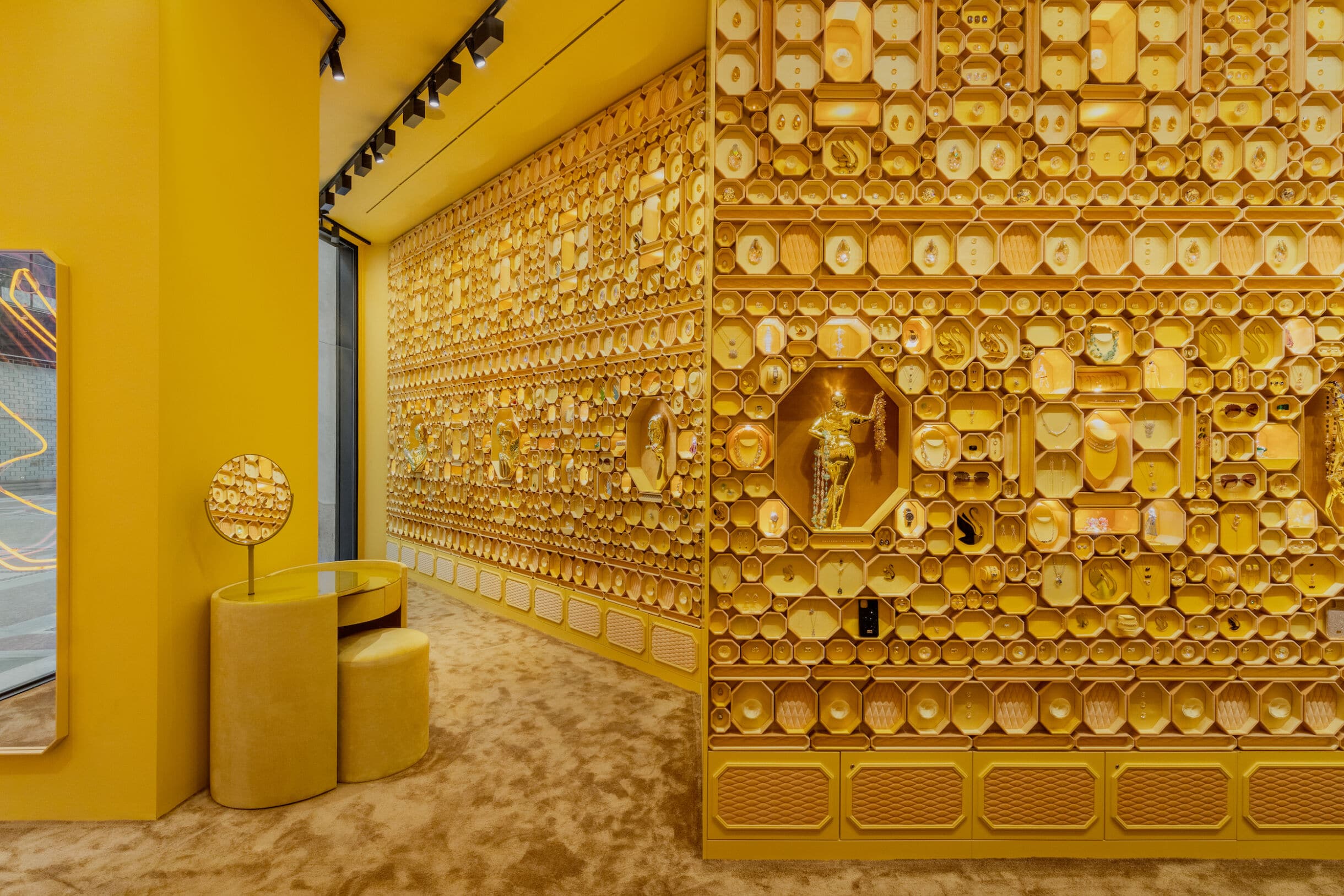 Gelbe Wabenwand mit Schmuckvitrinen im Swarovski Instant Wonder Store, Mailand