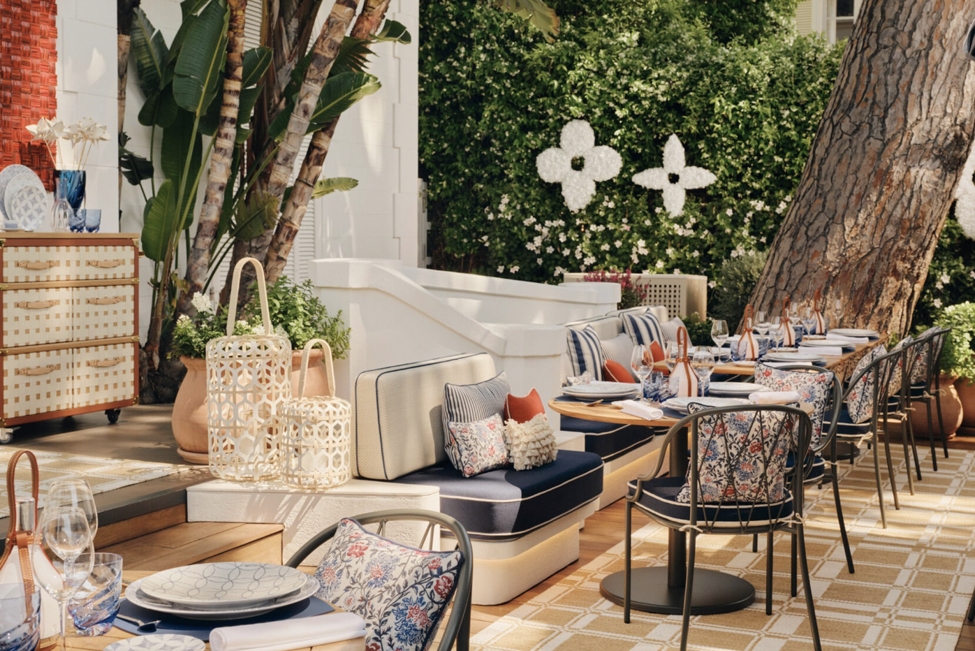 Outdoor lounge seating area with the Louis Vuitton flower motif worked into the hedge and striped cushions