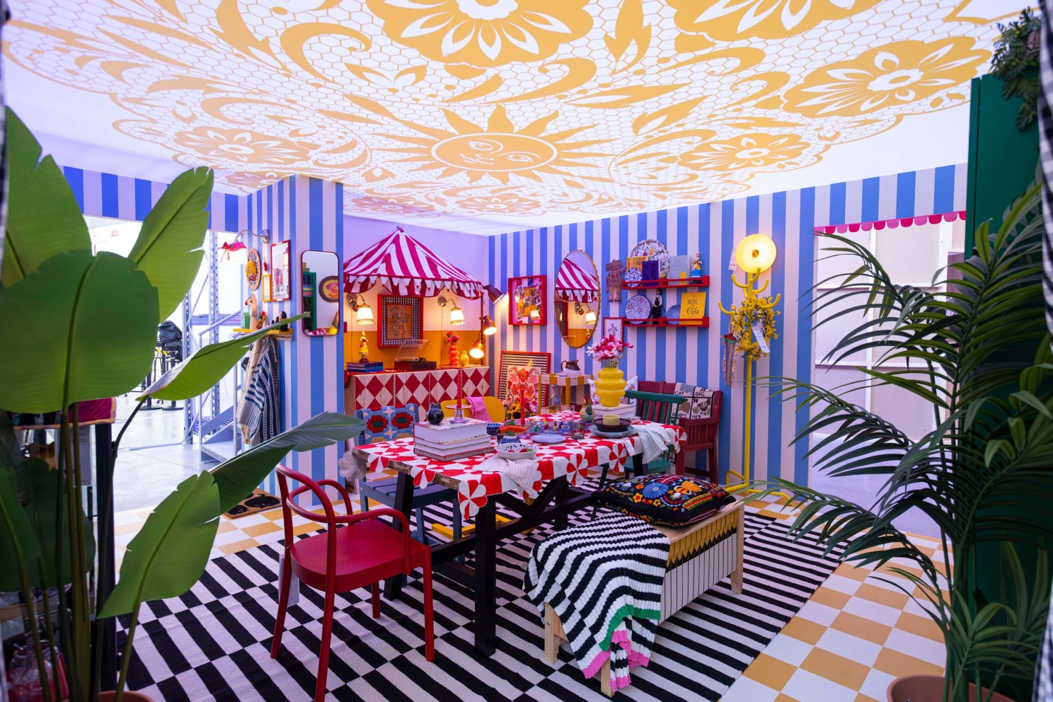 IKEA installation: brightly striped room with a set dining table and patterned floor at Milan Design Week