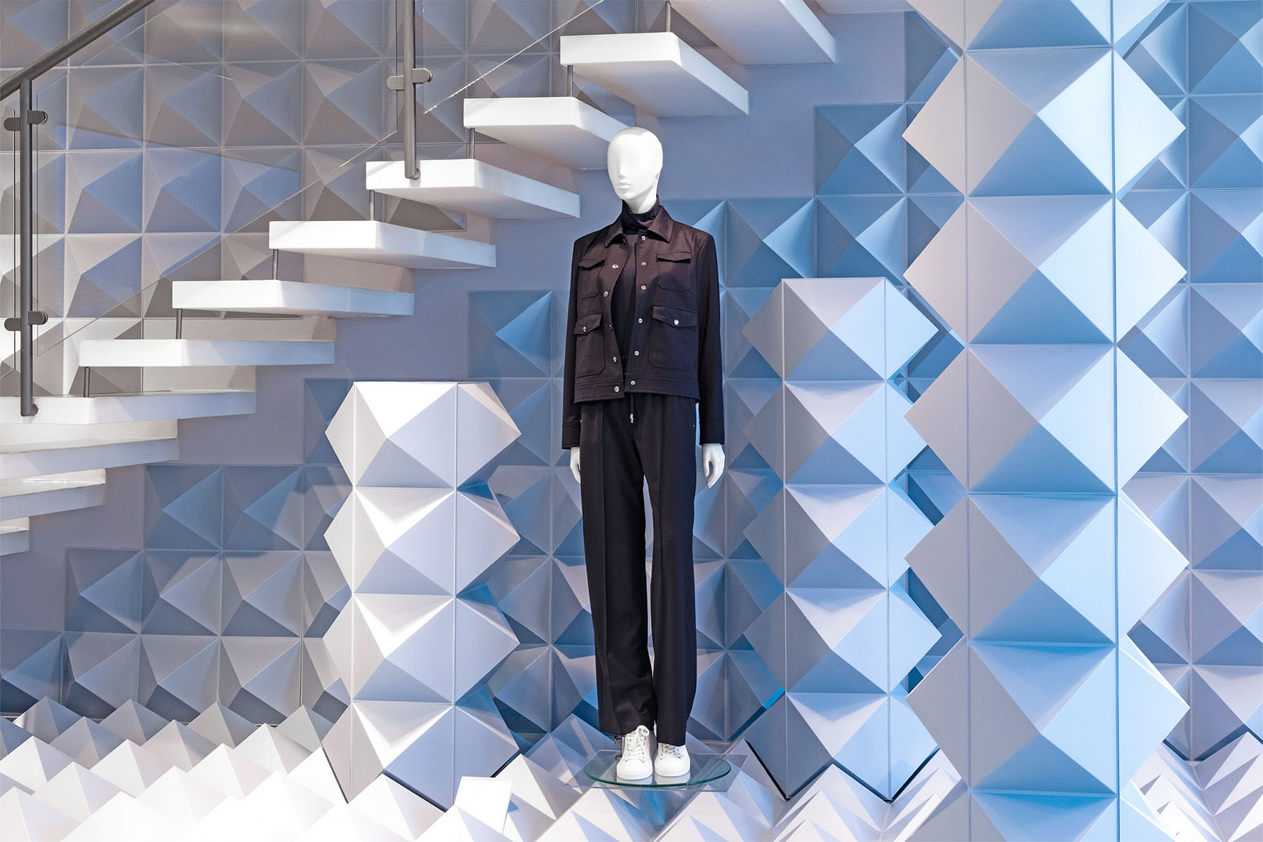 BOGNER-Store mit Mannequin vor der Pyramidenwand und weißer Skulpturtreppe