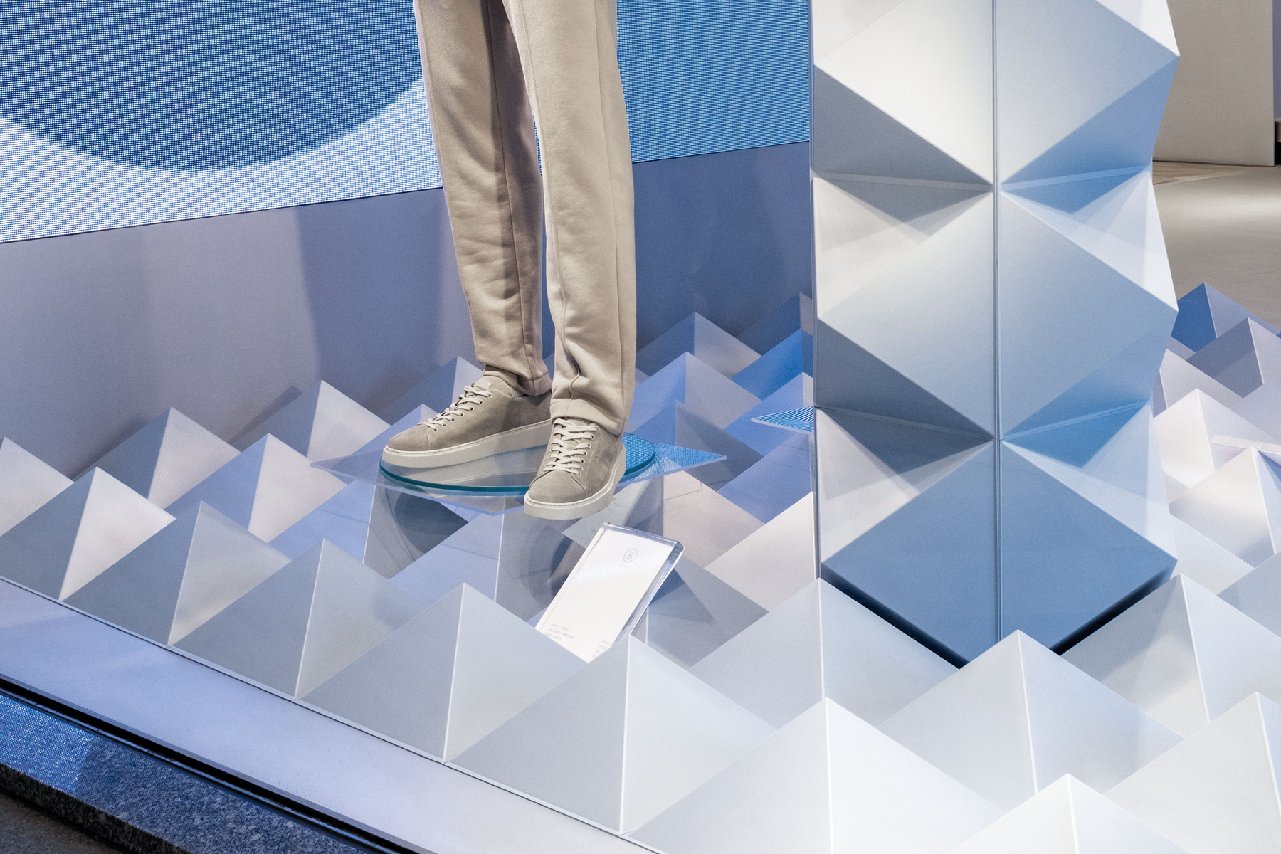 Detail: Mannequinfüße auf Glassockel über der Pyramiden-Bodenstruktur