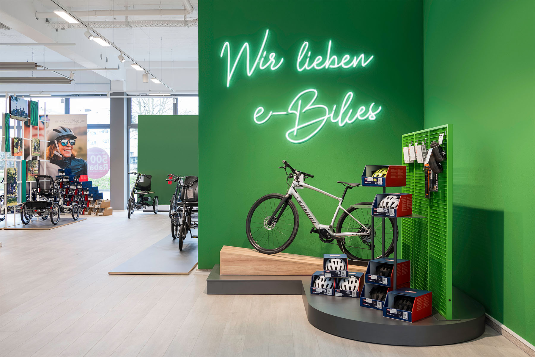 e-motion store with the neon sign "Wir lieben e-Bikes" above the bike and accessory display