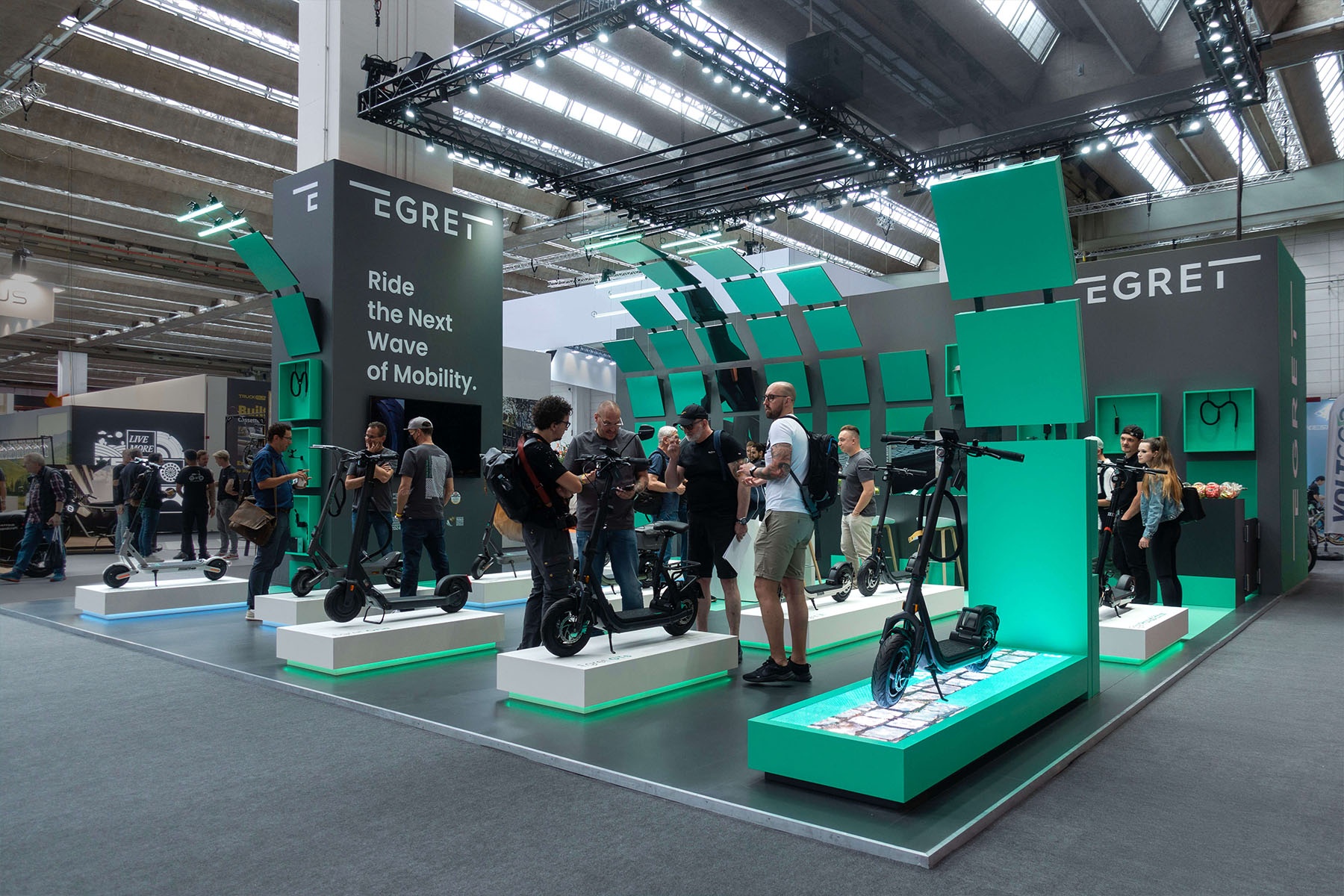 Egret-Messestand auf der Eurobike: E-Scooter auf beleuchteten Podesten unter dem Claim „Ride the Next Wave of Mobility".