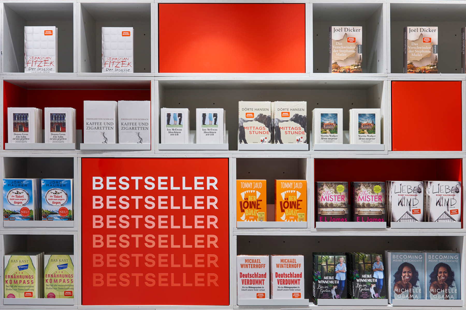 Shelf wall at Hugendubel with red panels and a repeated "Bestseller" typography highlighting the featured titles.