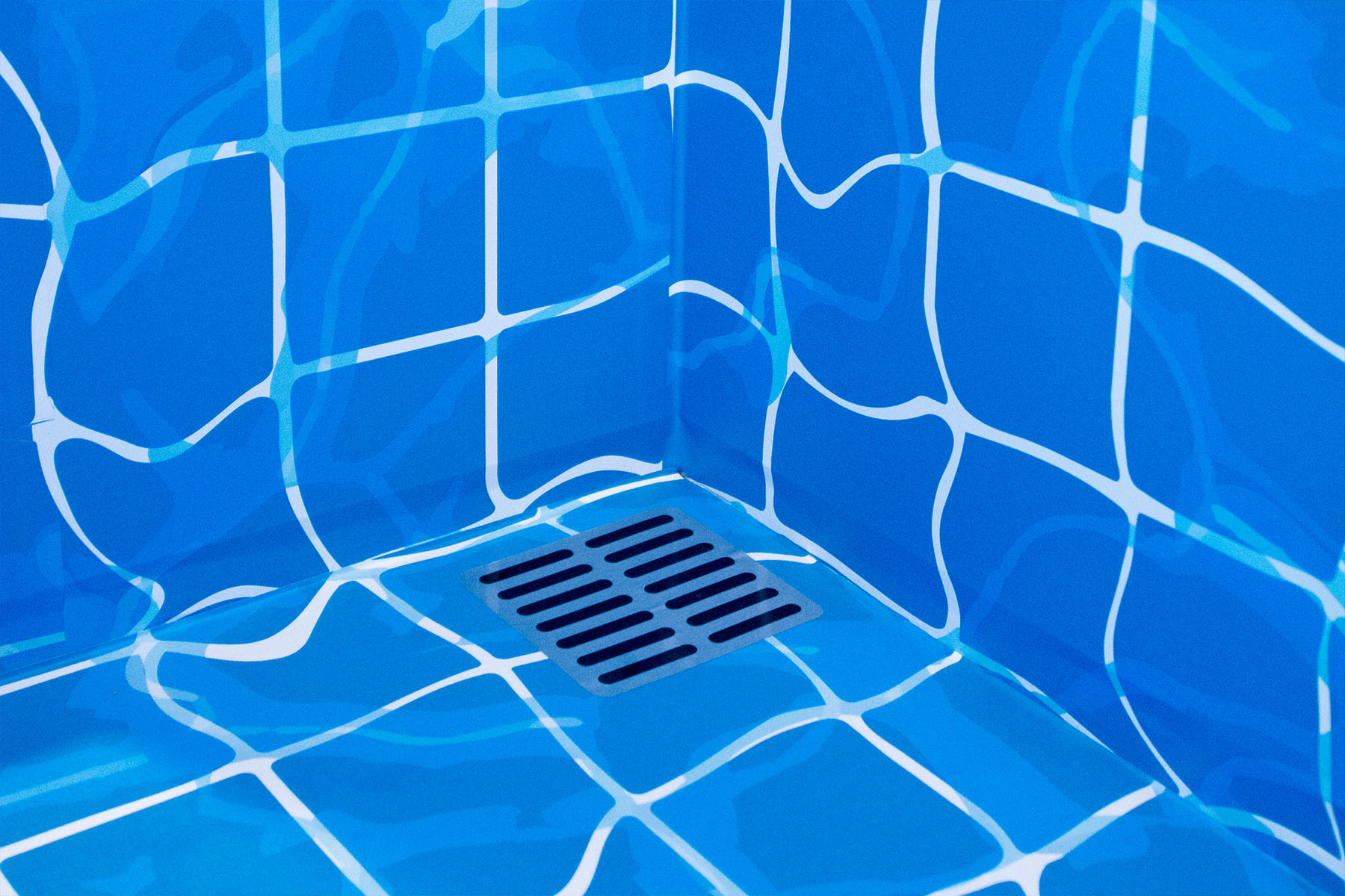 Detailaufnahme des blauen Pool-Kachelbodens mit Abflussgitter in der SportScheck-Umkleide.