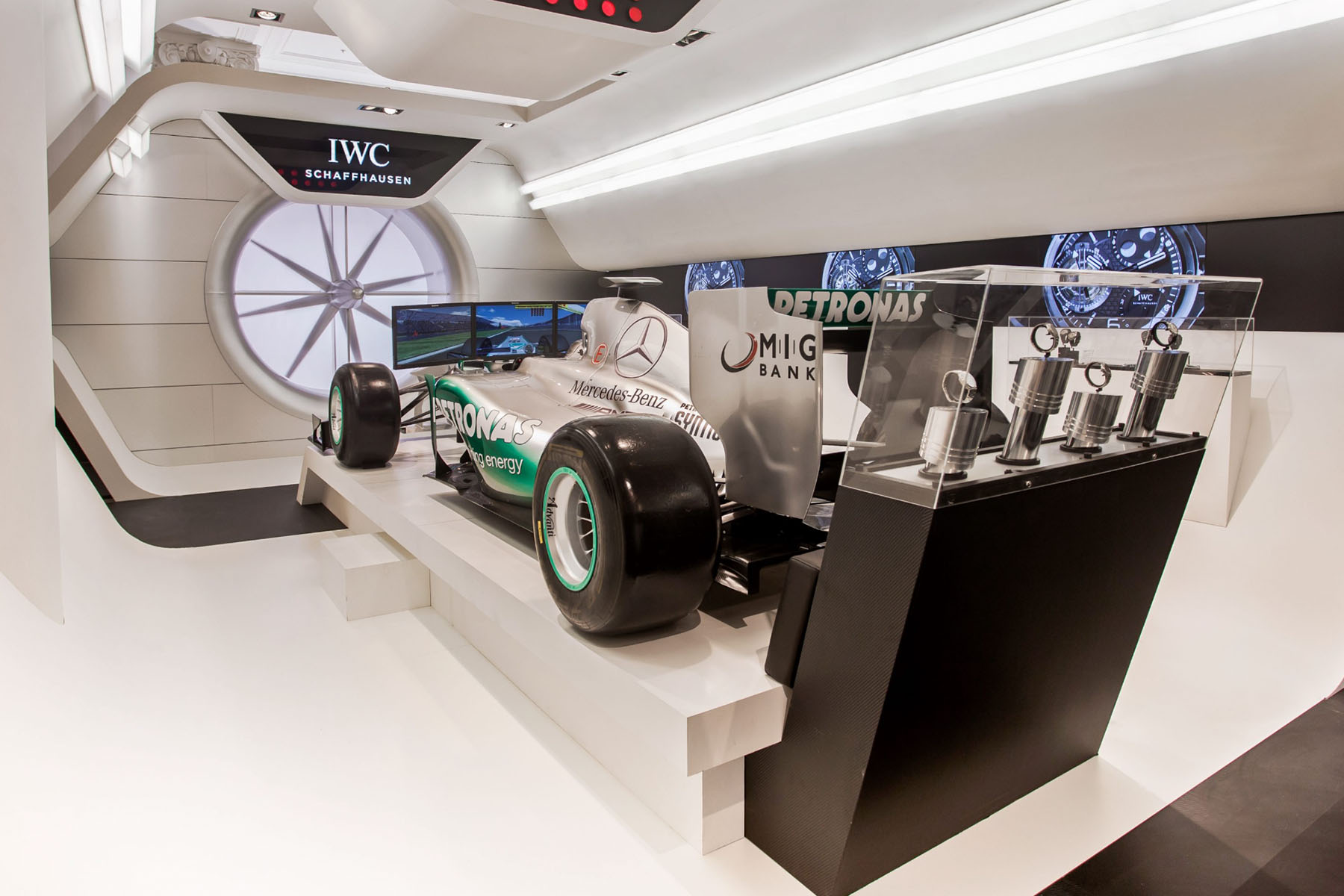 IWC-Schaffhausen-Pop-up mit F1-Rennwagen, runder Rad-Grafik und Uhrenvitrinen in futuristischem Raum