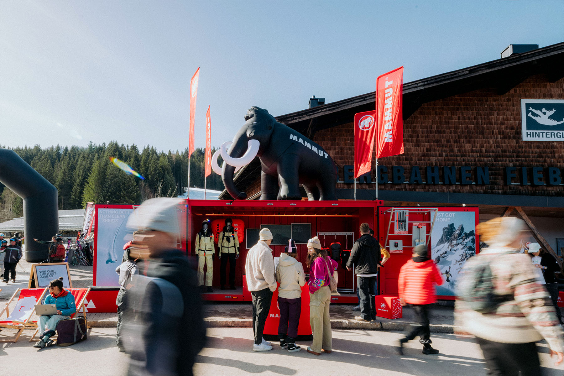 Mammut-Container mit aufblasbarem Mammut-Maskottchen auf dem Dach vor der Bergstation.