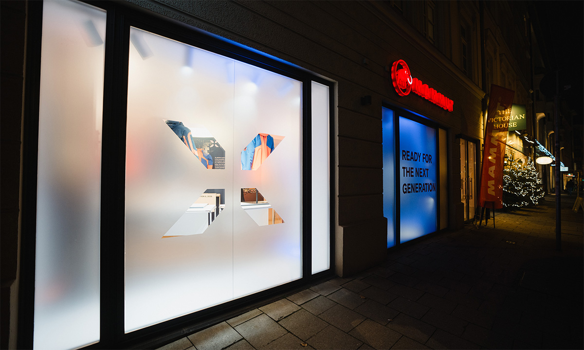 Beleuchtetes Mammut-Schaufenster bei Nacht mit X-förmiger Produktinszenierung