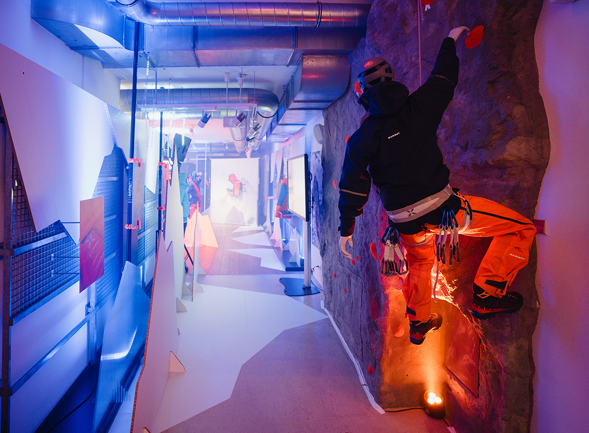 Person klettert an der künstlichen Felswand-Installation beim Mammut-Presse-Event