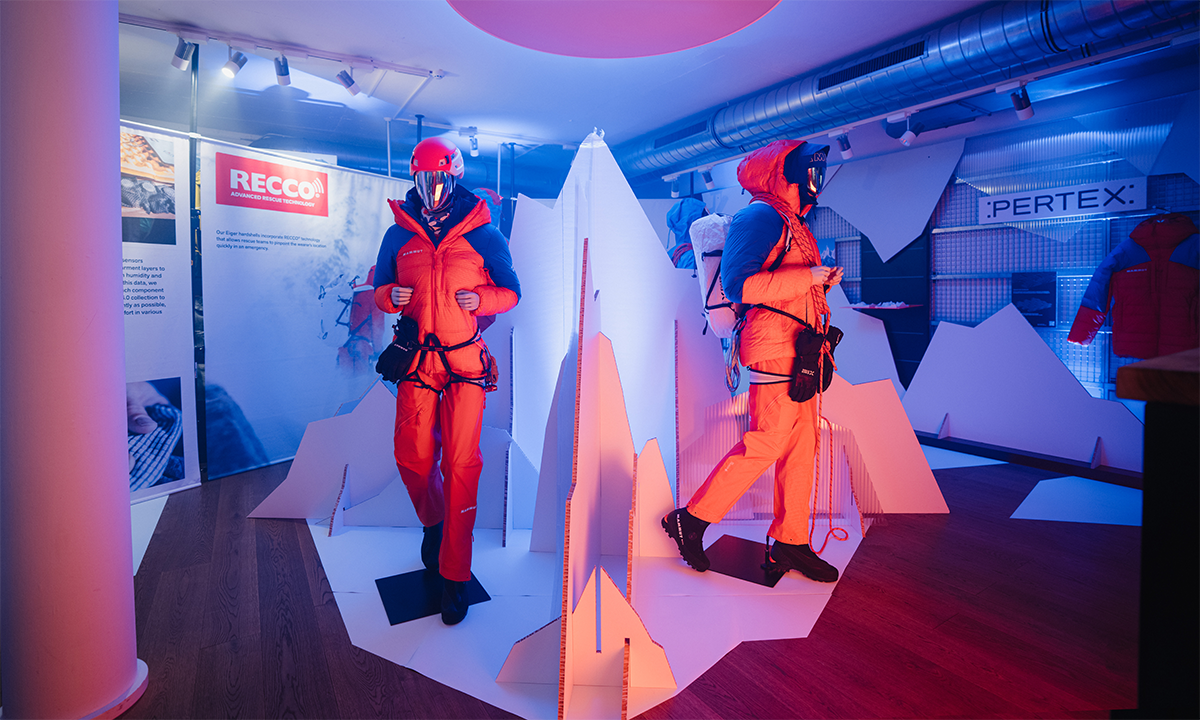Mammut-Showroom mit Bergsteigerausrüstung vor Kulisse aus Kartonbergen
