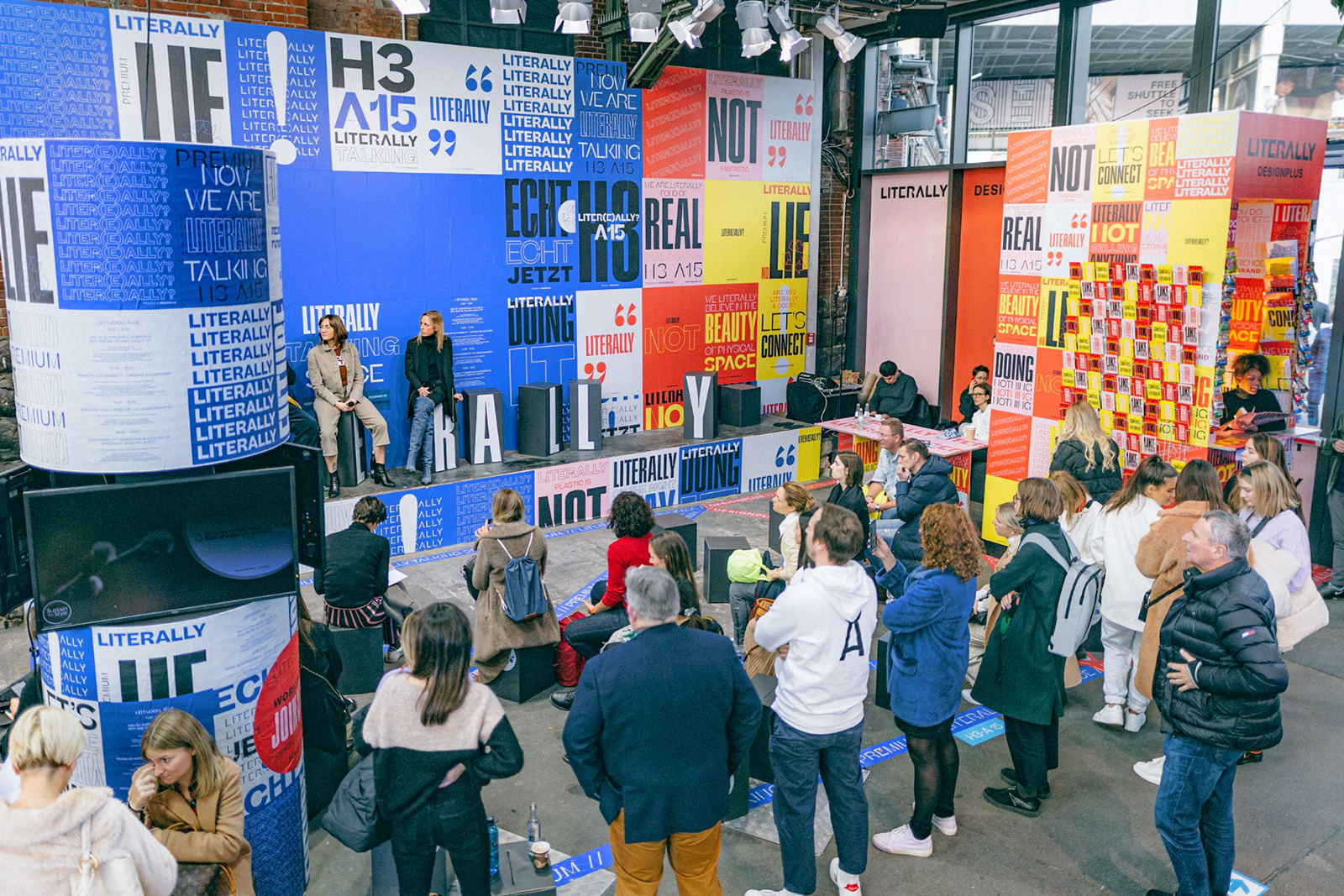 Bühnendesign mit farbiger Typo-Kulisse und Publikum bei einer Veranstaltung