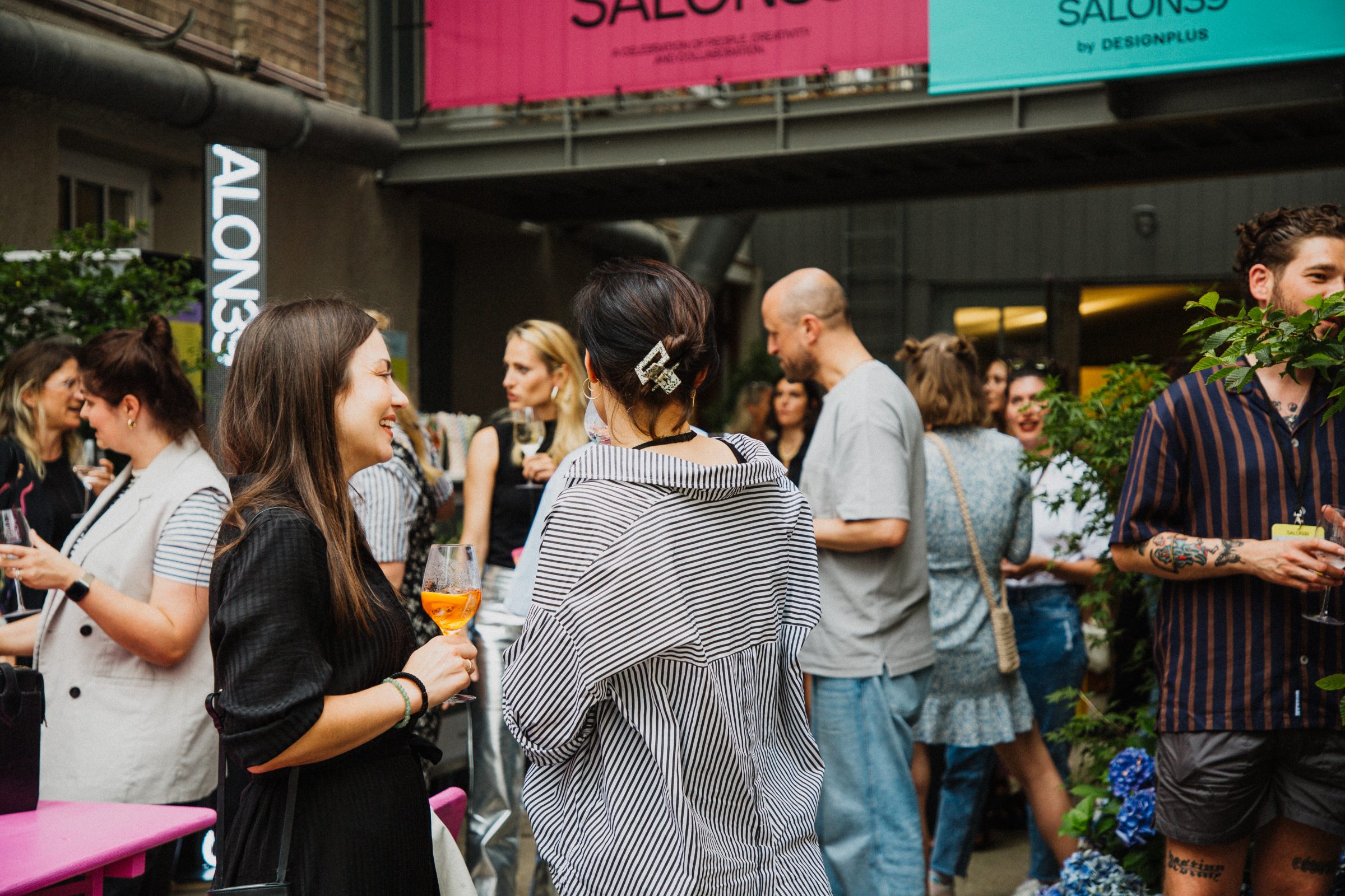 Guests mingle with drinks in the courtyard beneath the SALON39 banners.