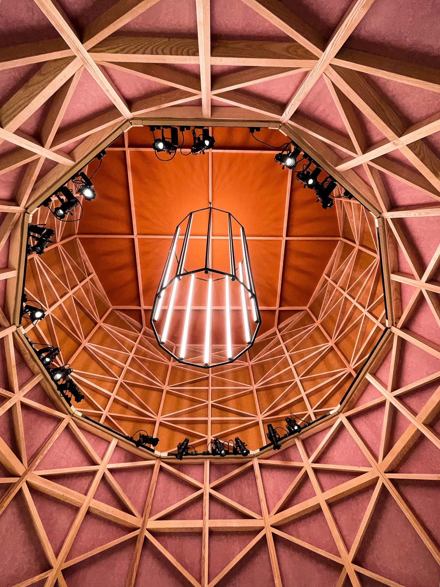 Upward view into an octagonal timber structure with spotlights and a central light fixture