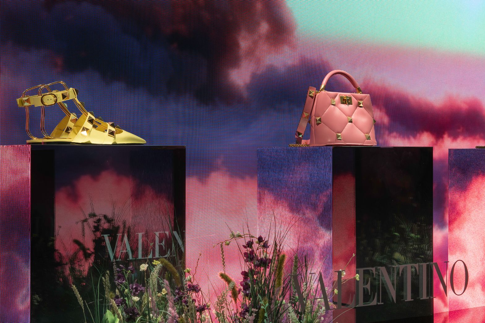 Close-up of a Valentino shoe and bag against the pink LED cloud backdrop