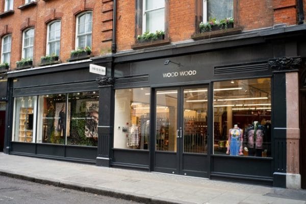 Schwarze Ladenfront des Wood-Wood-Stores mit Schriftzug in einer Londoner Backsteinstraße