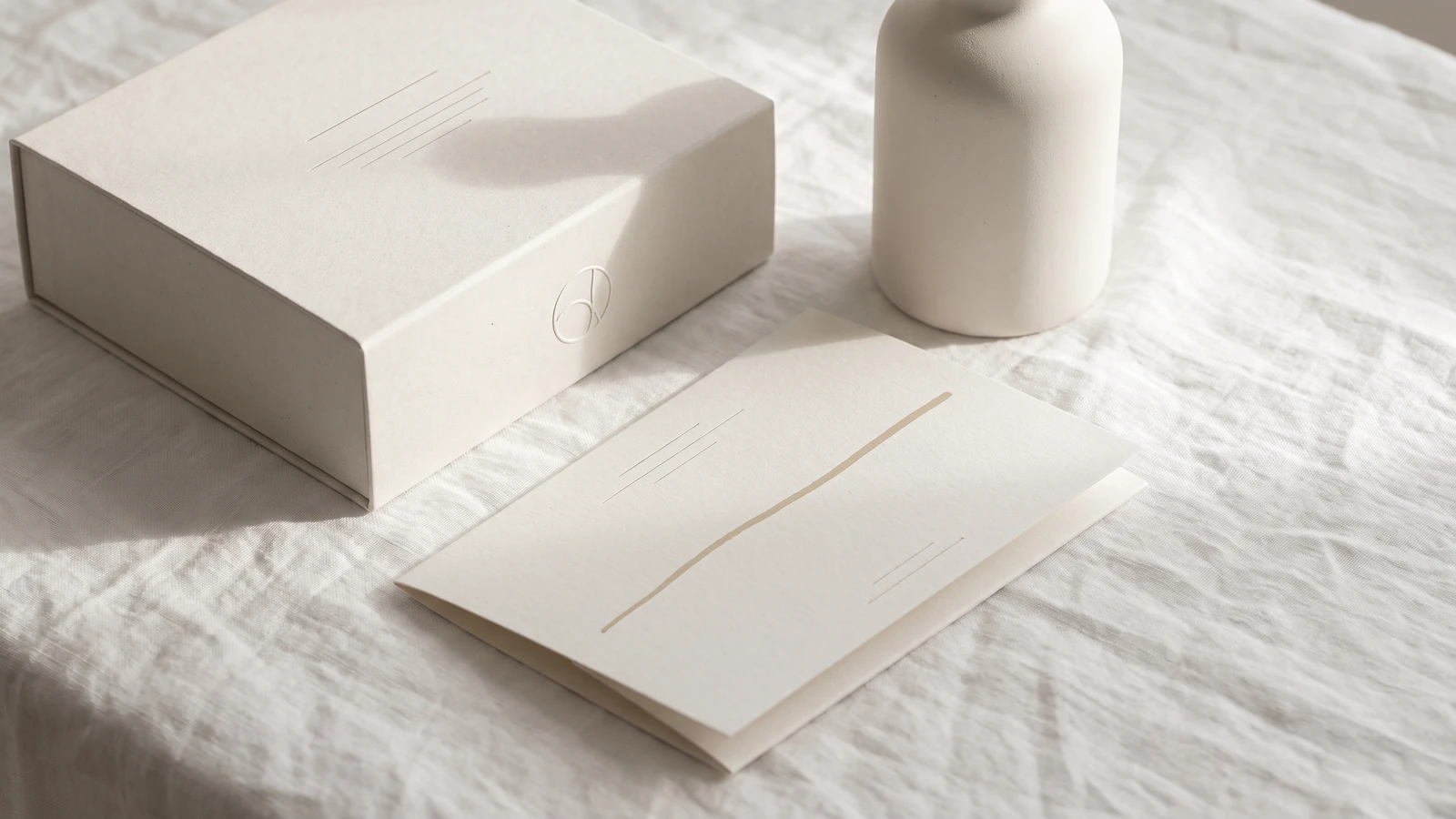 Cloud Dancer neo-minimalism graphic design trend example: soft white premium packaging with debossed mark and warm paper texture