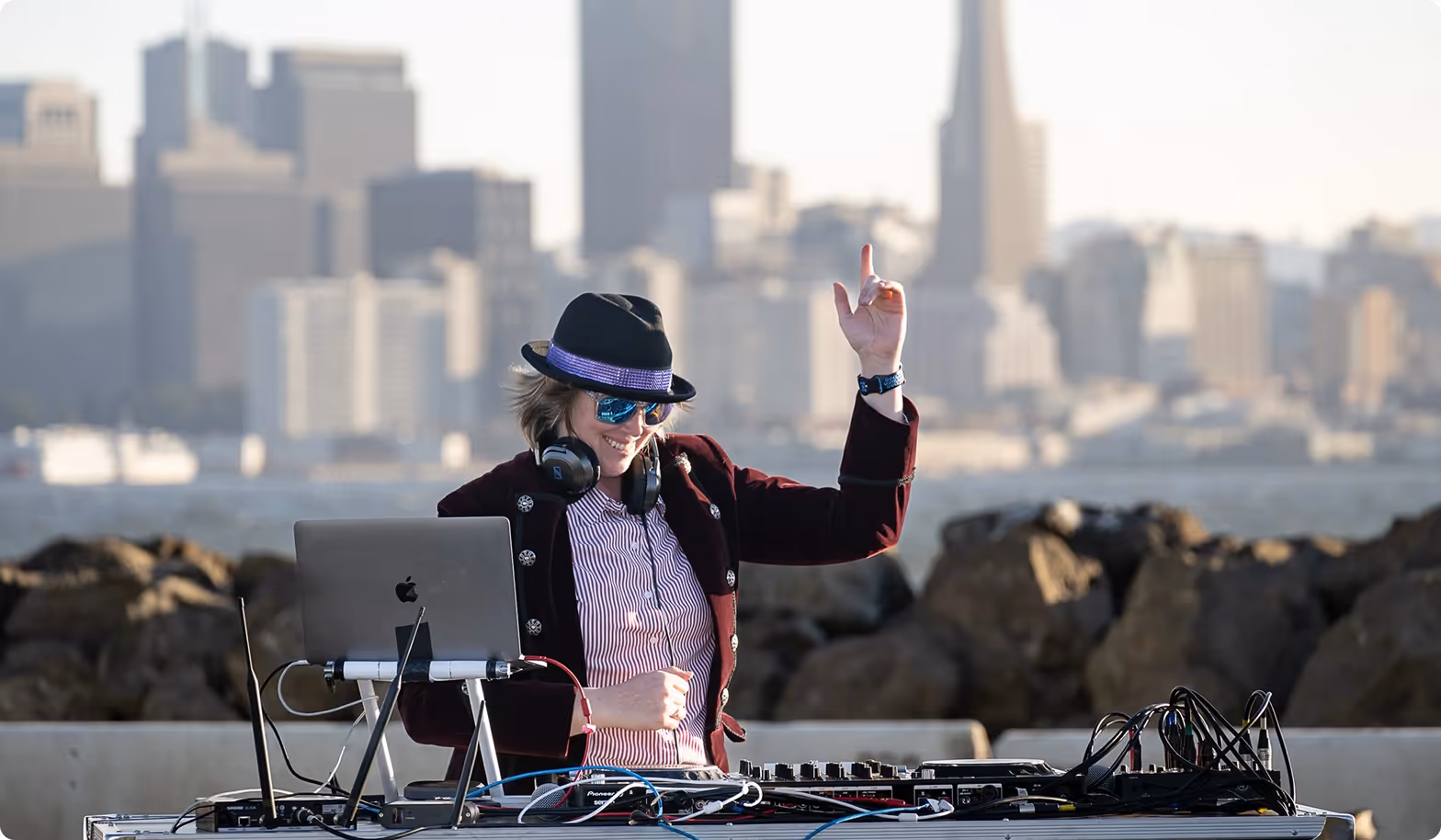 Ersson (DJ Airsun) DJing outdoors with the San Francisco skyline behind her