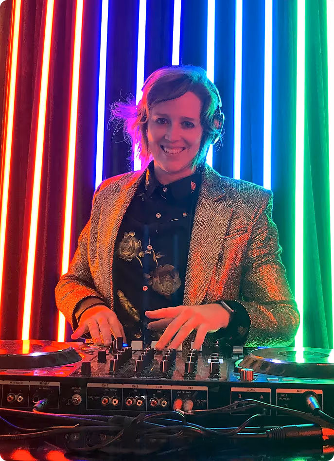 DJ Airsun (Ersson) in a gold jacket at the decks in front of rainbow LED lights