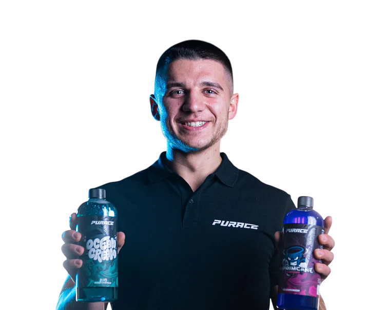 Man in black Purace shirt smiling, holding two Purace Ocean Cream and Primate bottles.
