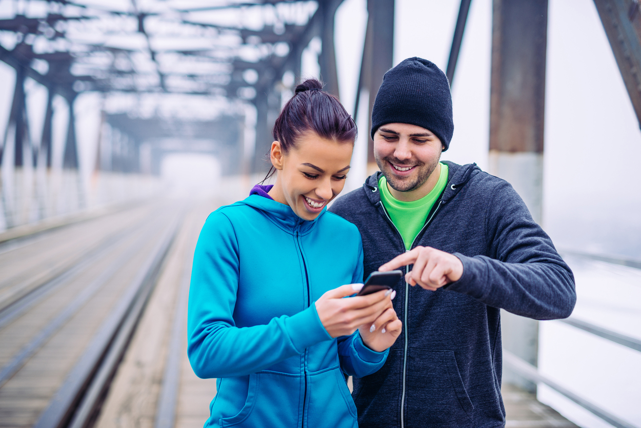 Alt: Smiling couple checking out a notification on their phone.