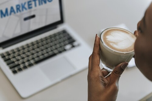 A person drinking coffee while handling marketing because they know the answers to all the questions about web stories.