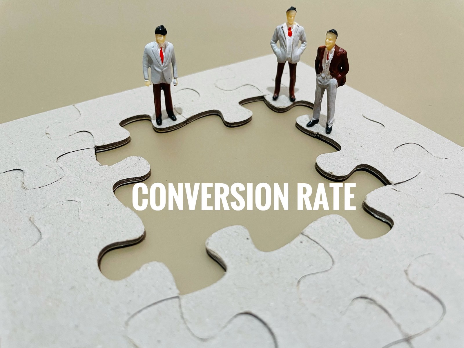 Figurines looking at conversion rates as a missing part of a larger puzzle.