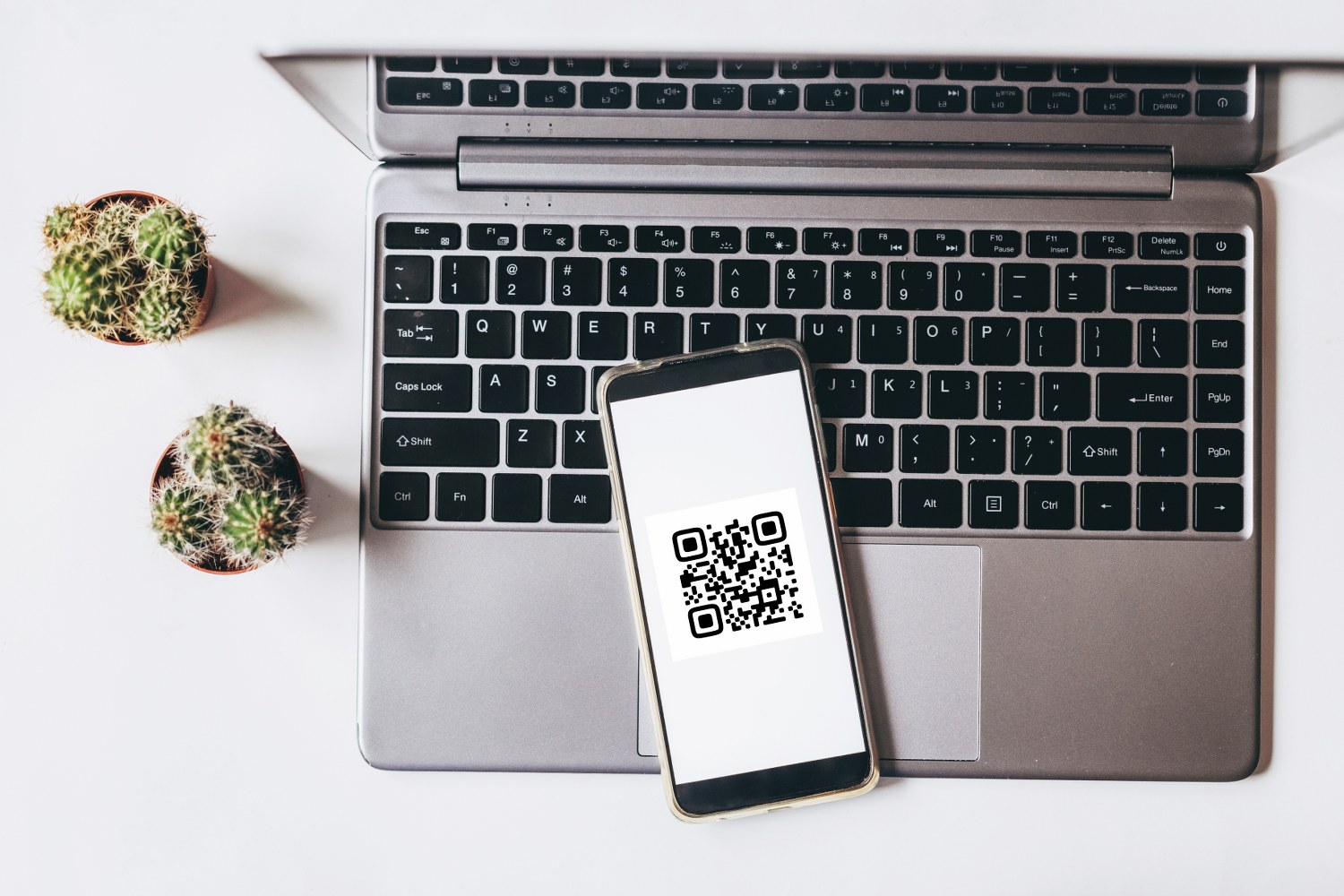 QR code on a phone next to a laptop