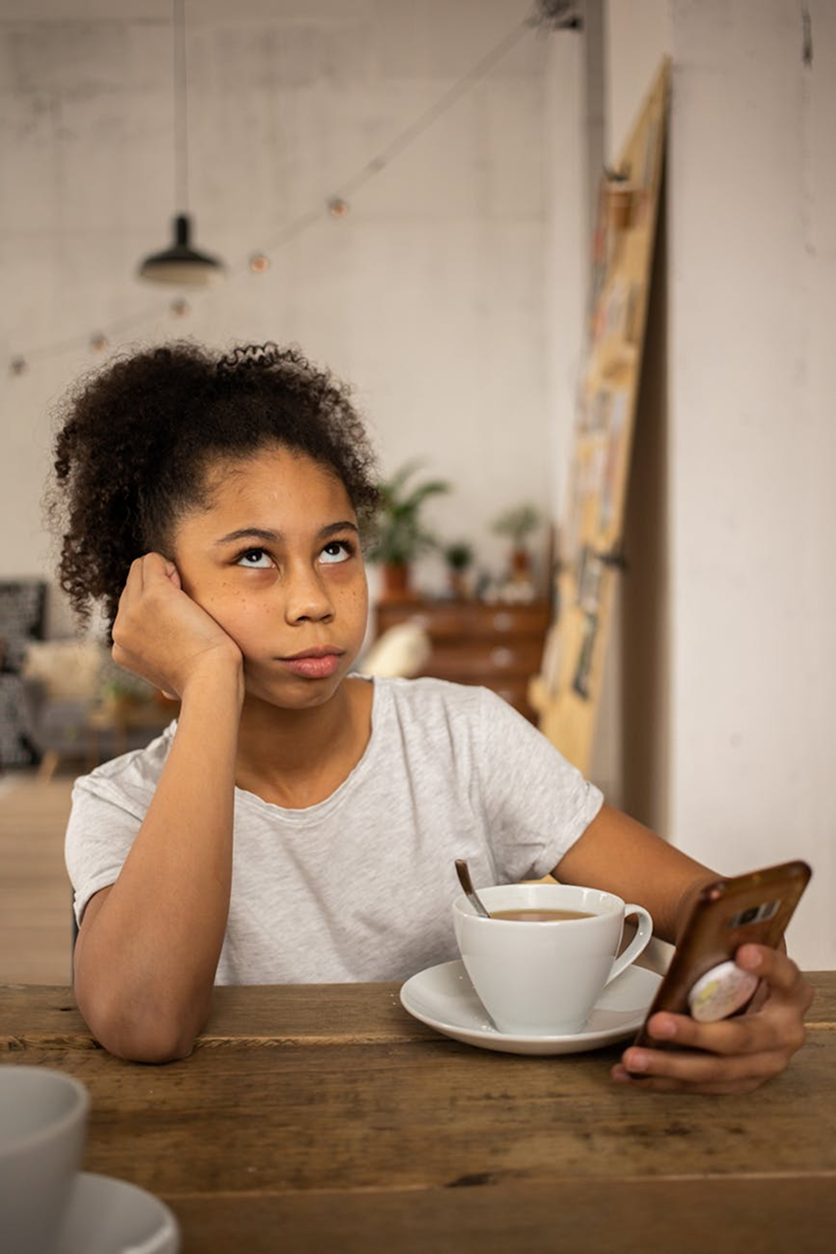 A girl feeling annoyed while looking at her phone.