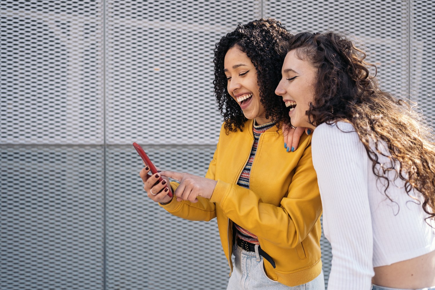 Two girls viewing in-app stories on a phone.