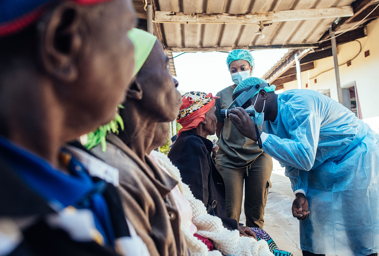 Photo of a surgeon screening local community members for Trachomatous Trichiasis via the Accelerate Programme which works to eliminate Trachoma from communities.