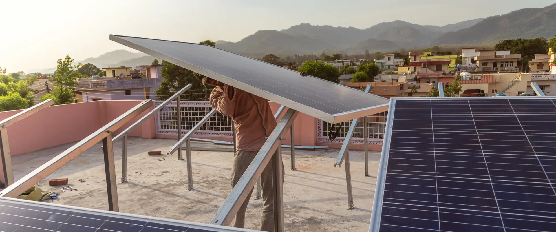 Photo of a person installing solar panels in India.