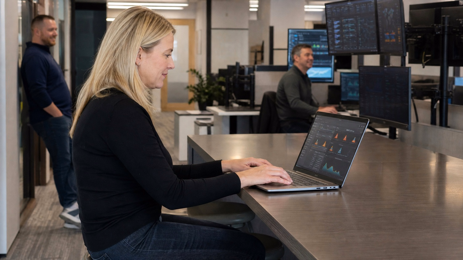 Woman at bar desk typing on laptop security dashboard 60