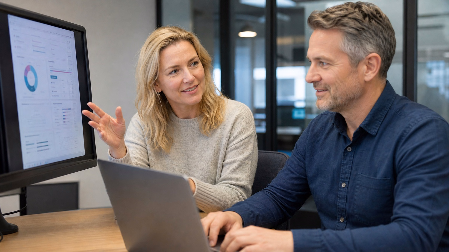 Woman explains security to man taking notes, office setting