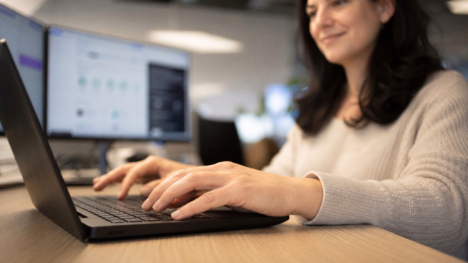 Womans hands typing on laptop keyboard, blurred background 63
