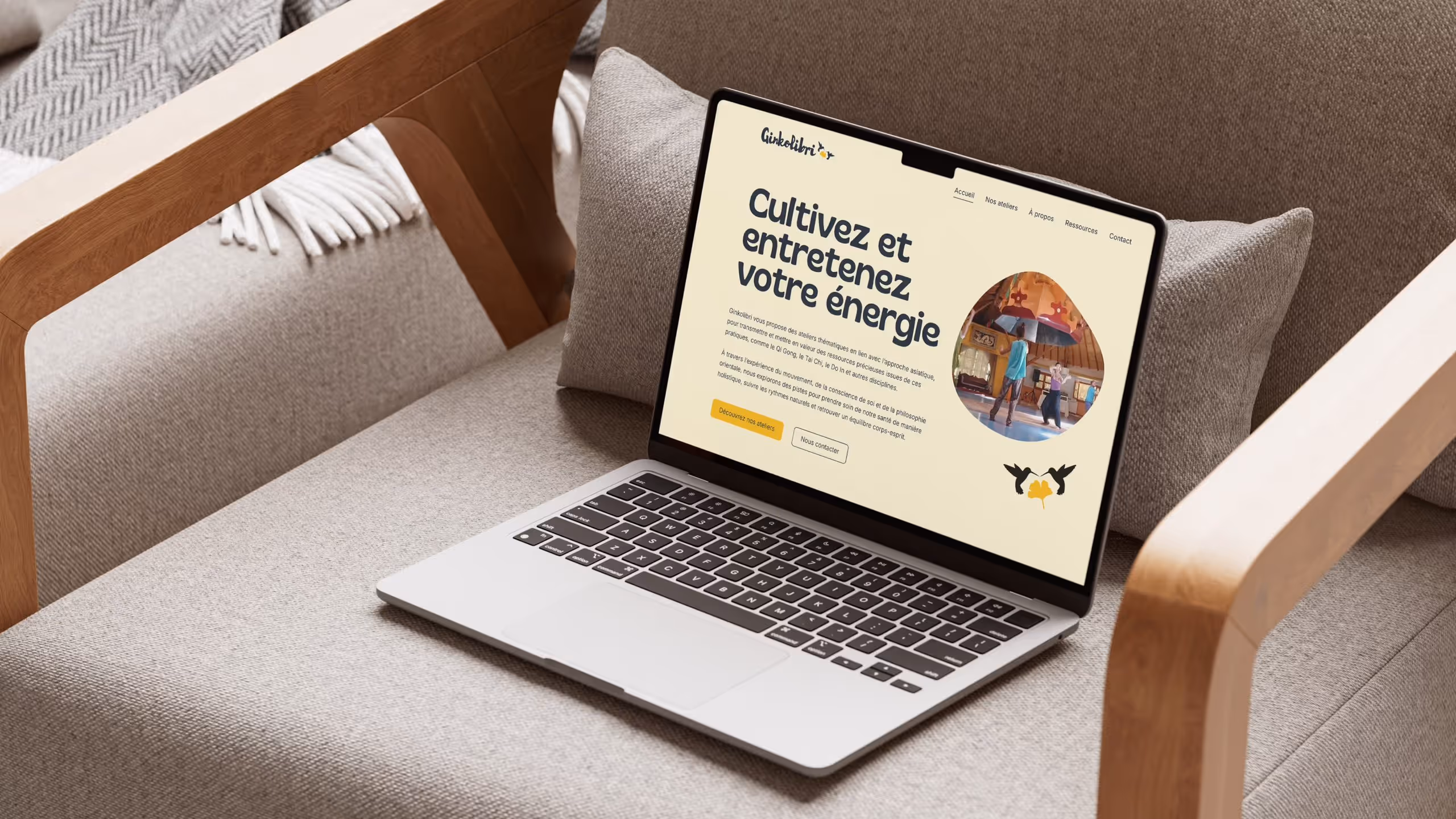 Ordinateur portable ouvert sur un canapé montrant un site web sur l'énergie et les ateliers asiatiques.