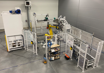Installed automated box packing and palletizing line with robot handling, conveyors and machine guarding