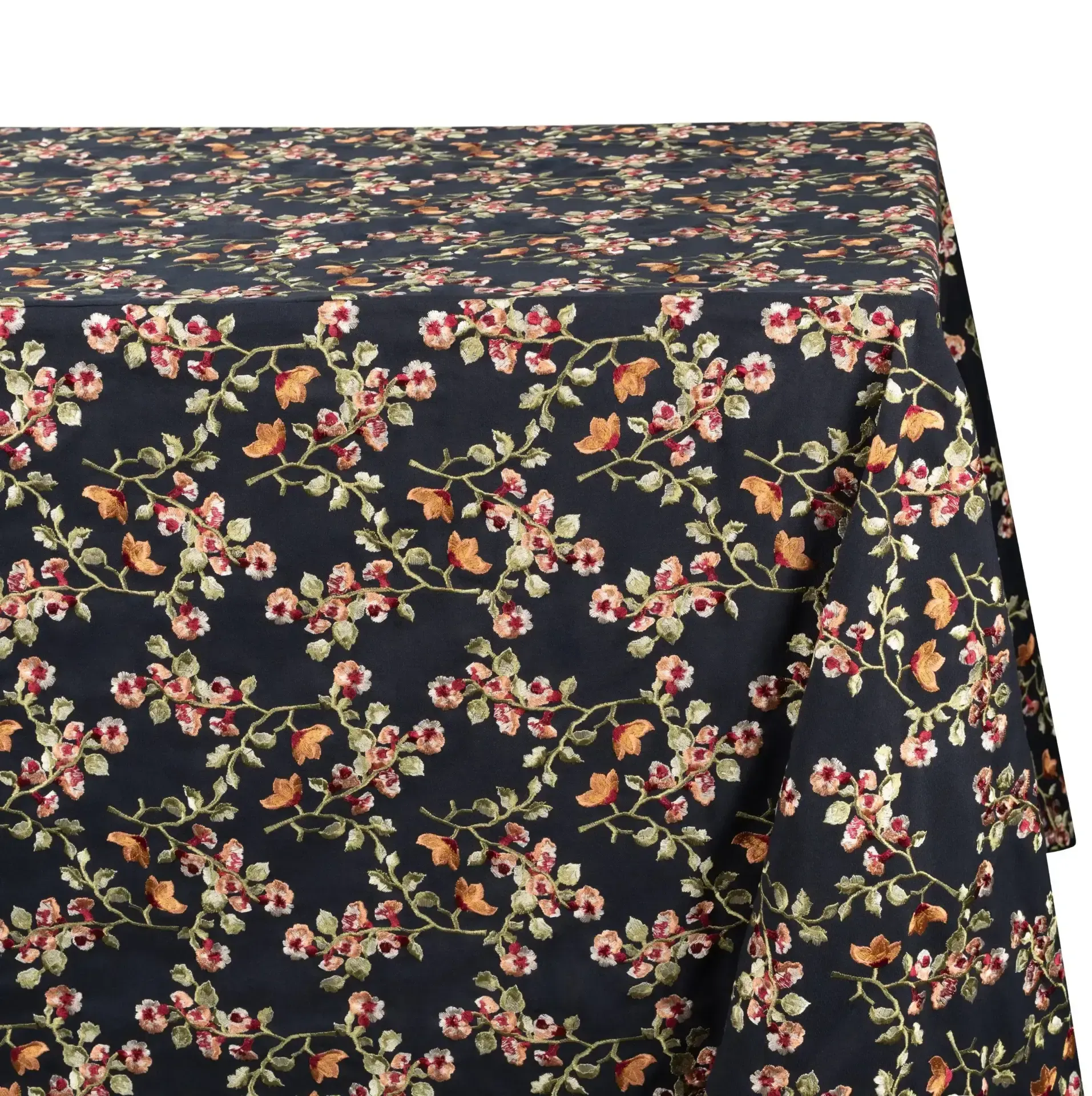 A dark navy blue tablecloth with a repeating floral pattern in pink, orange, and green. The pattern consists of stylized branches and blossoms.