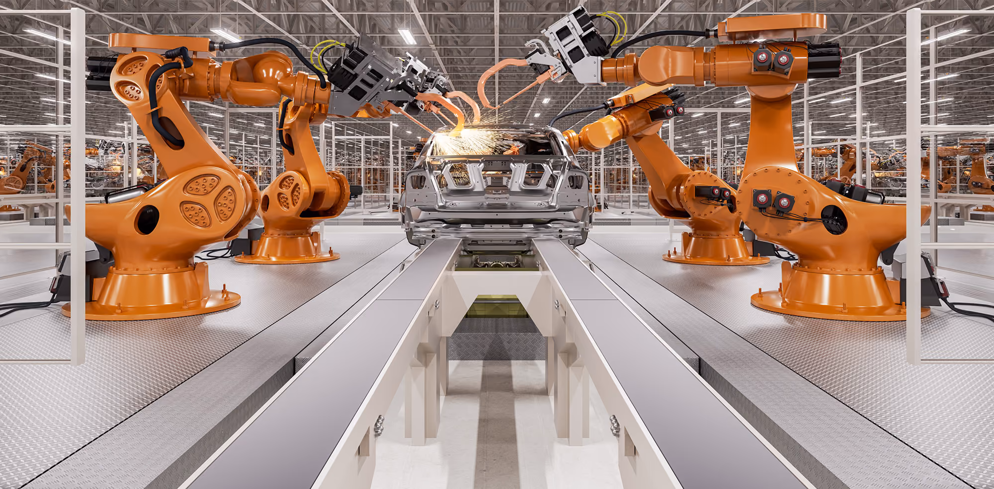 Orange robotic arms welding metal car body on an assembly line in a large factory.