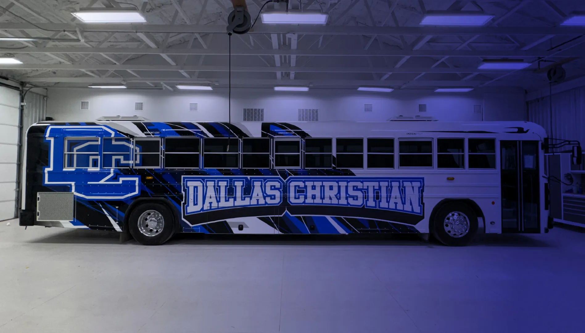 Dallas Christian wrapped bus parked in National Wrap Co. service bay