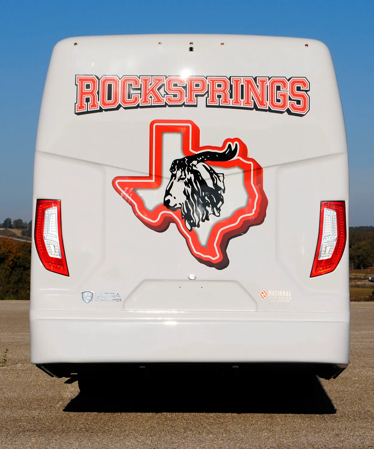 Rear view of a Rock Springs Independent School District Ultra Coachliner wrapped by National Wrap Co.