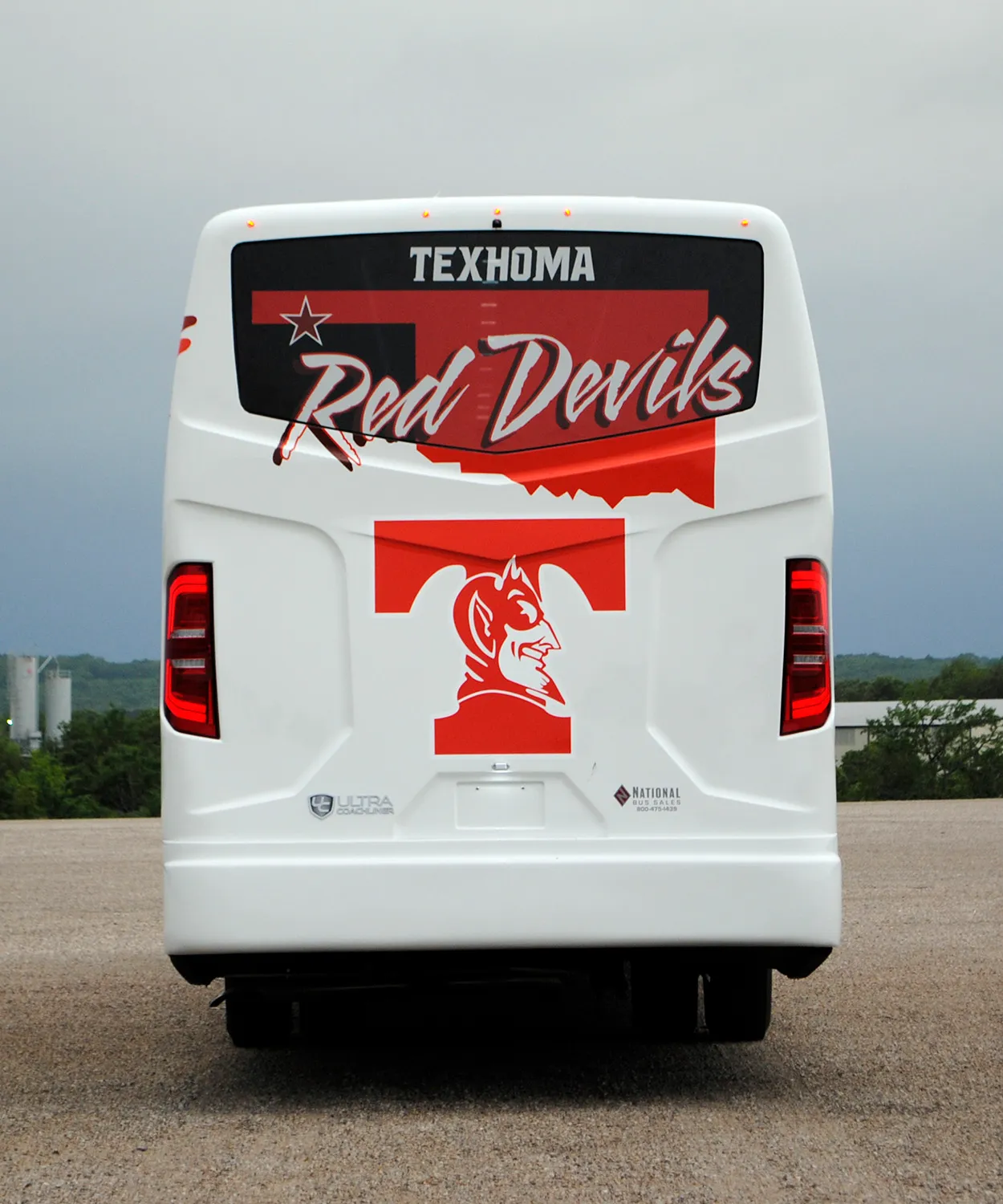 Rear view of a Texhoma Red Devils Ultra Coachliner wrapped by National Wrap Co.
