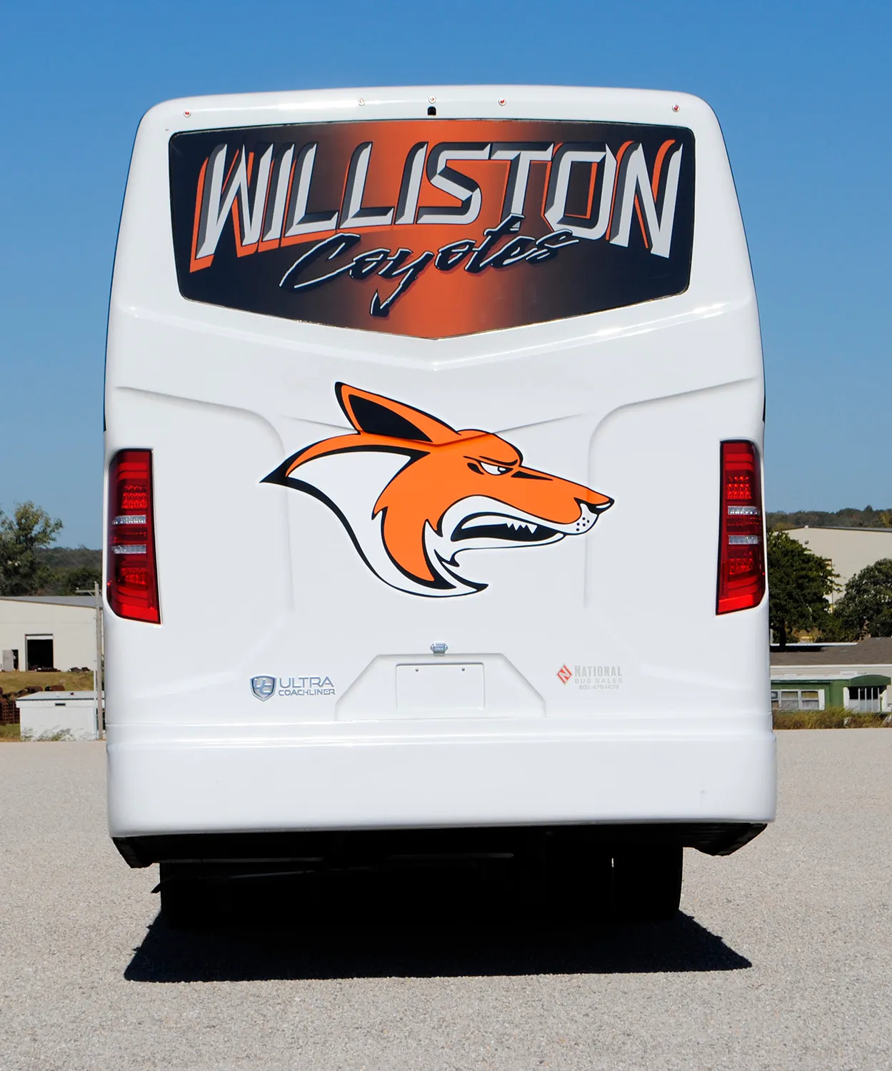 Rear view of a Williston Coyotes Ultra Coachliner wrapped by National Wrap Co.