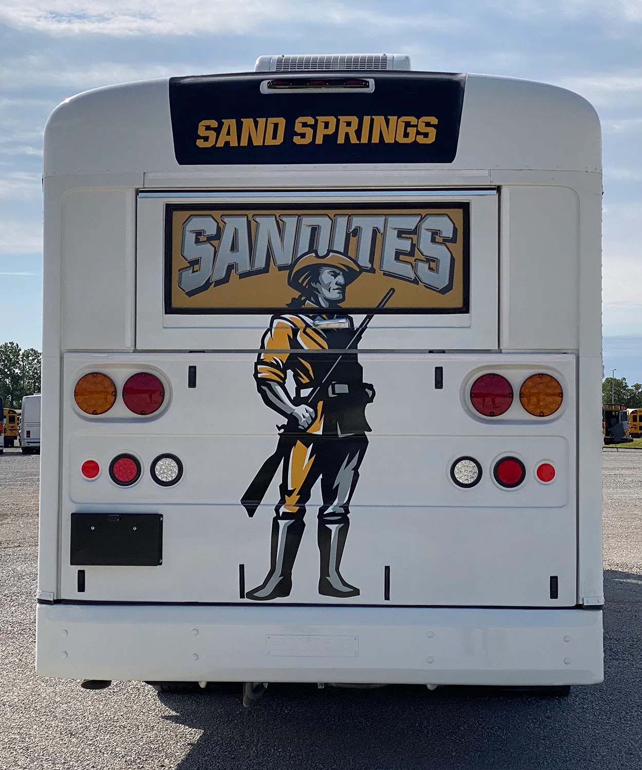 Rear view of a Sand Springs Sandites Mountain bus wrapped by National Wrap Co.