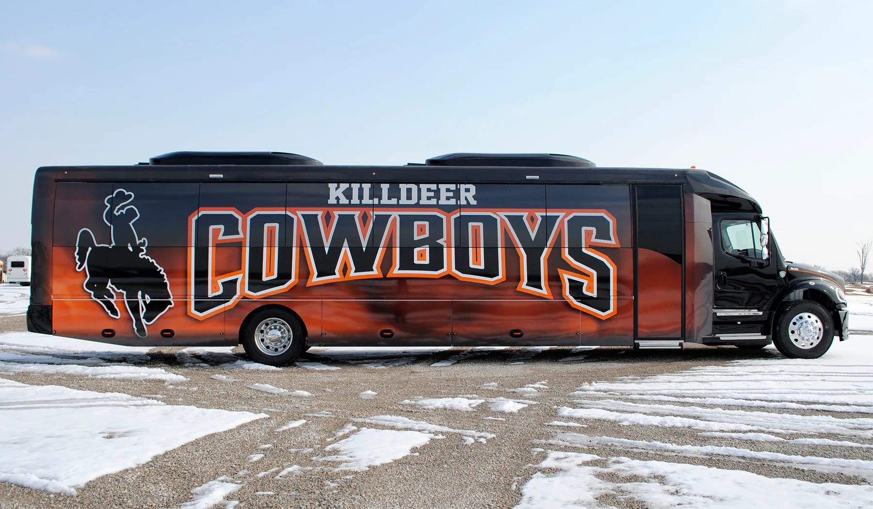 Side view of a Killdeer Cowboys Ultra Coachliner wrapped by National Wrap Co.