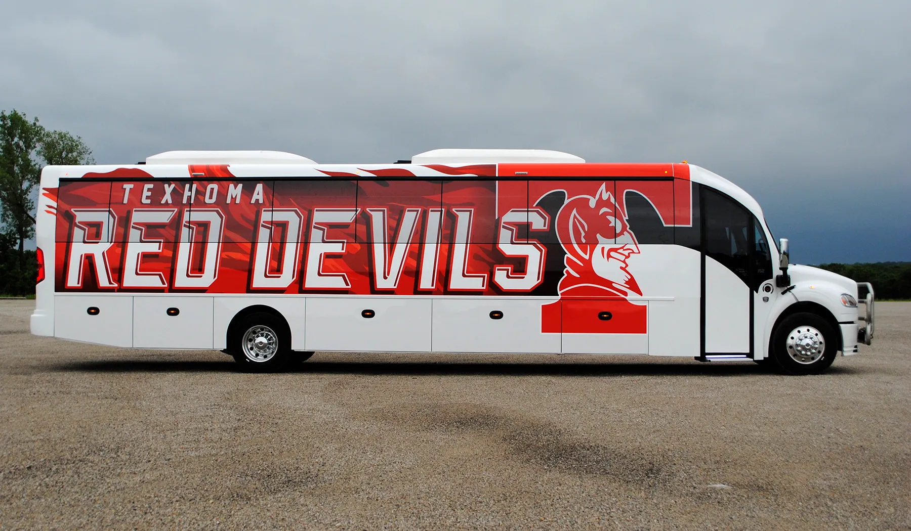 Side view of a Texhoma Red Devils Ultra Coachliner wrapped by National Wrap Co.