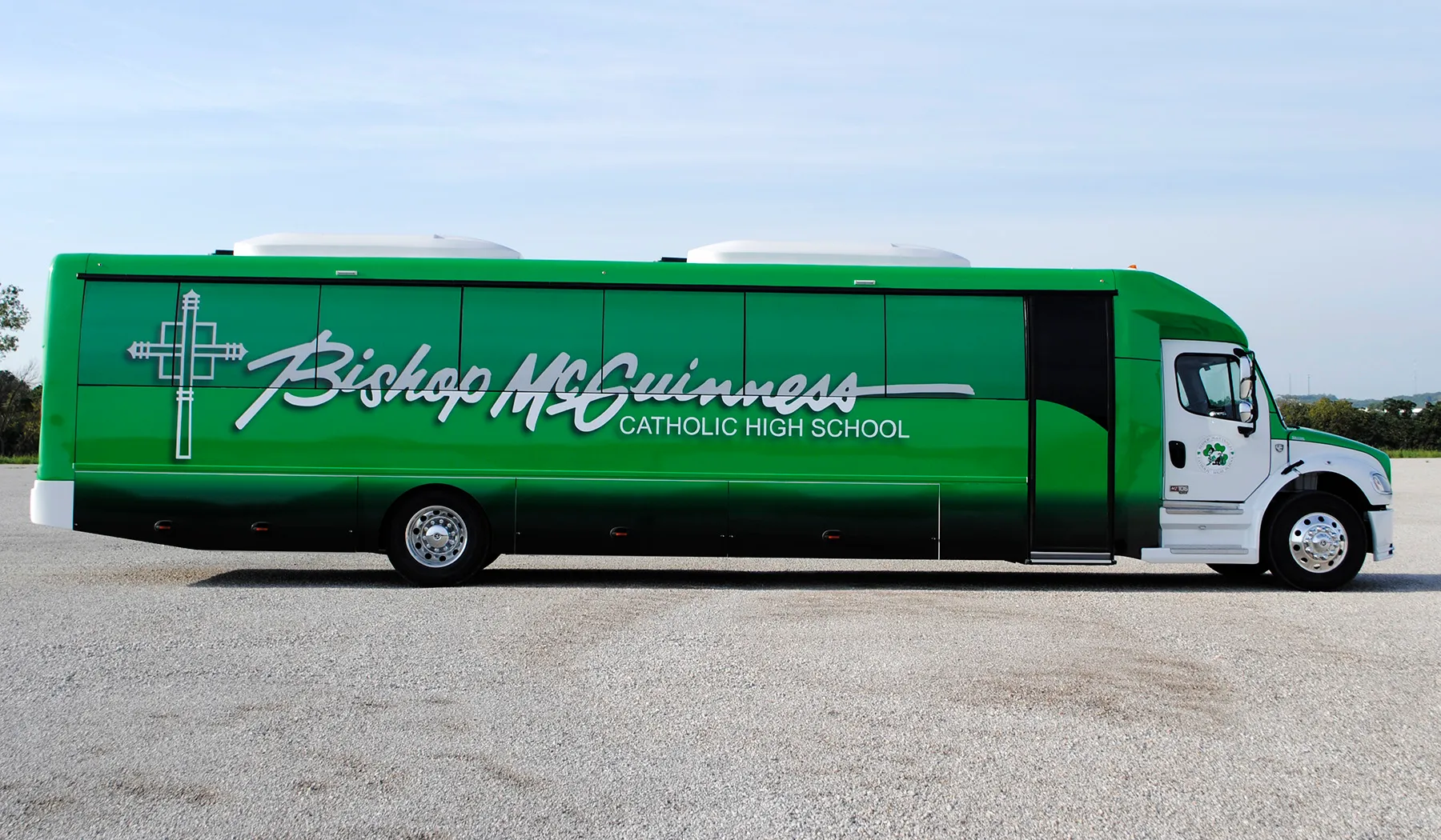 Side view of a Bishop McGuinness Catholic High School Ultra Coachliner wrapped by National Wrap Co.