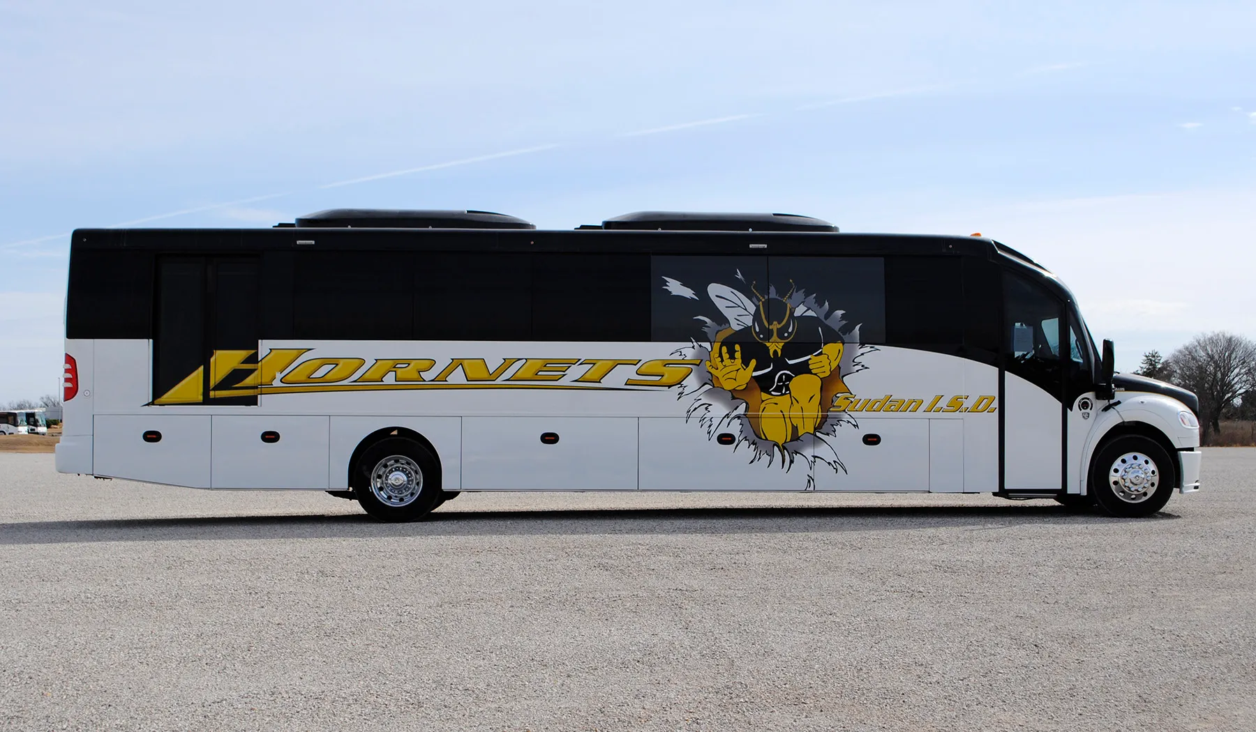 Side view of a Sudan Hornets Ultra Coachliner wrapped by National Wrap Co.