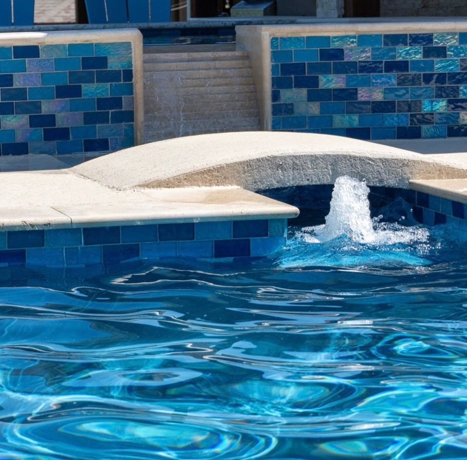 Custom built Austin pool with blue tile water fountain and curved seating