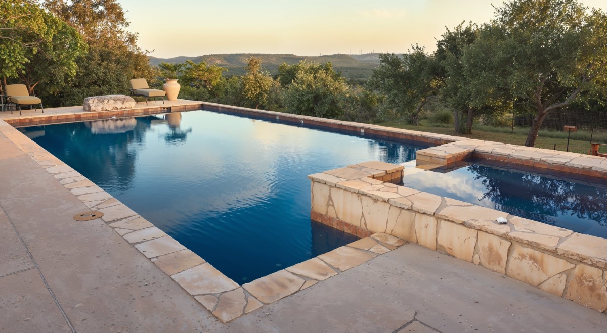 Custom pool design with stone features overlooking scenic valley landscape